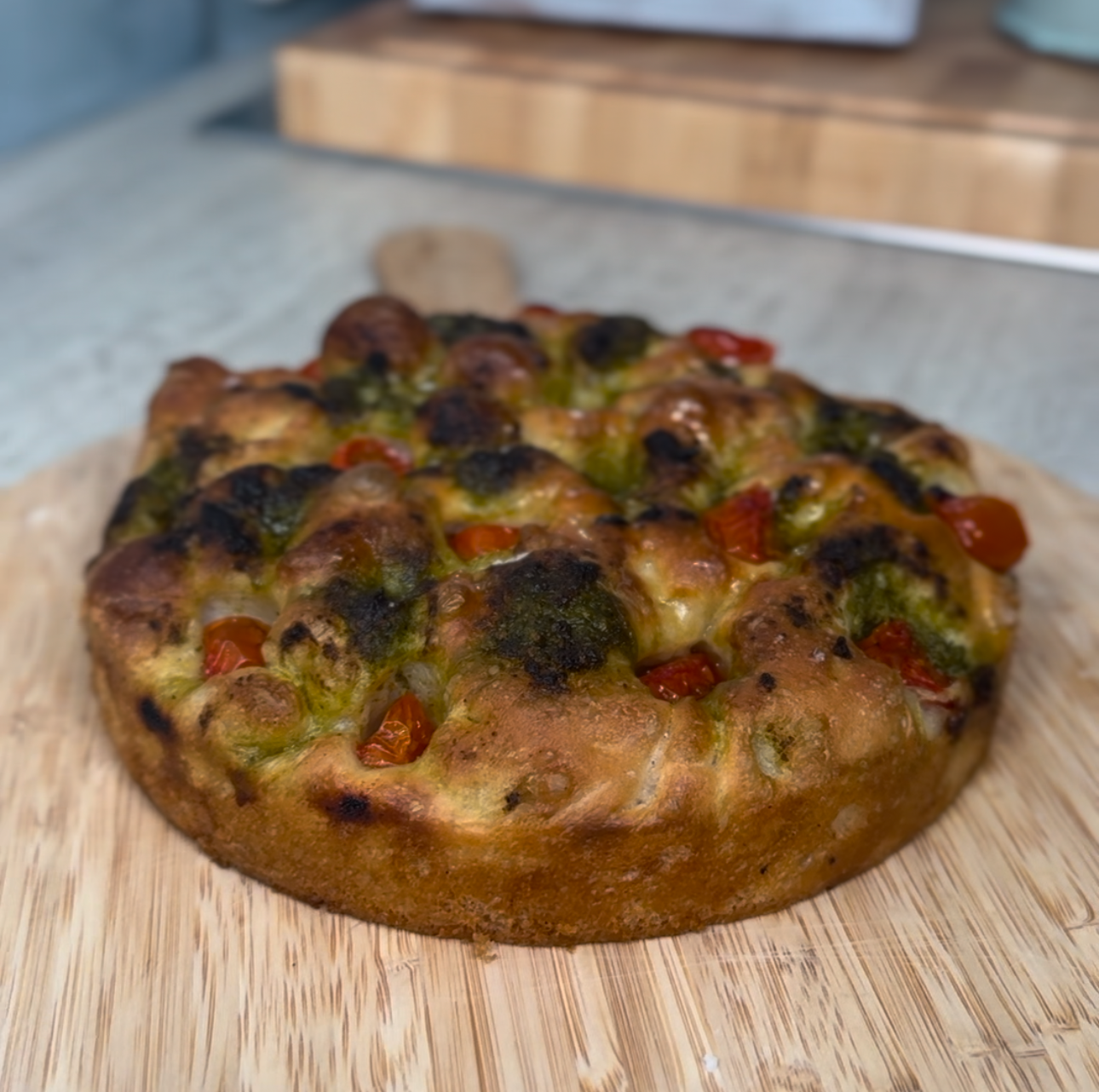 A freshly baked focaccia showing the pesto and tomatoes