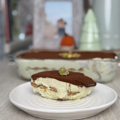 A slice of tirmaisu showing the layers of pale green filling and soaked lady fingers